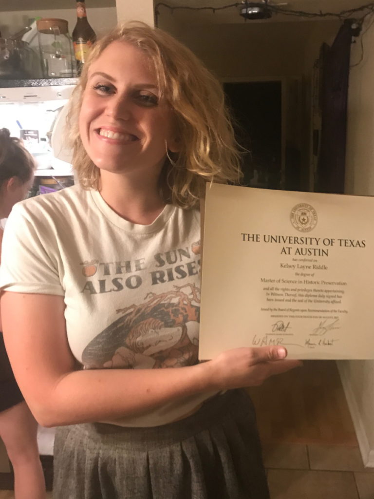 Kelsey R. holding her Masters degree certificate