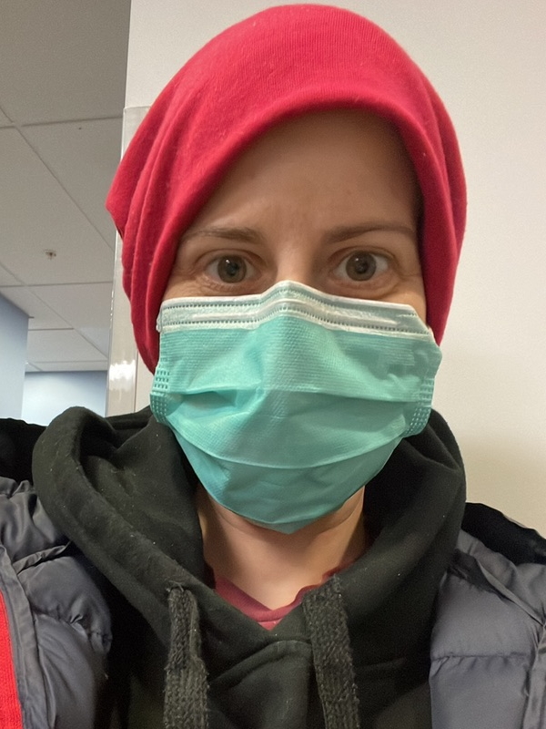 Anna T. in mask and hoodie