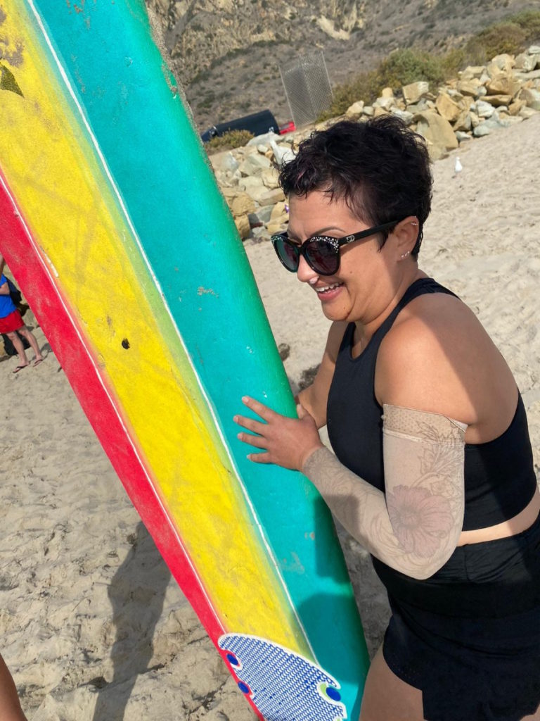 Renee F. holding surfboard