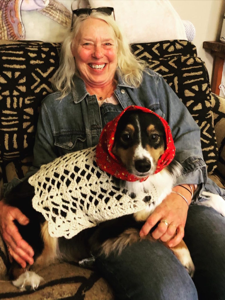 Vickie D. seated with dog on lap