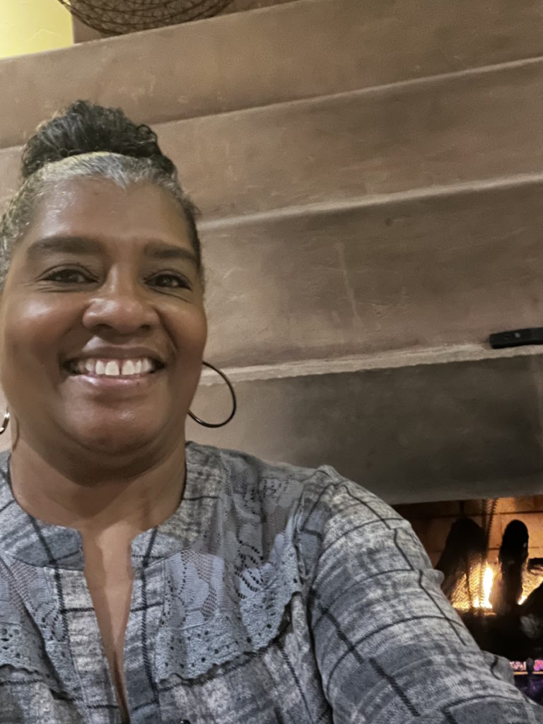 Marsha in front of fireplace