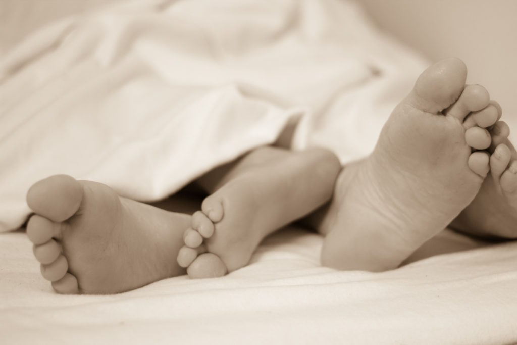 couple's feet in bed